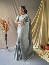 Beautiful Linen Silk Saree is having silver motif weaves all over the body of the saree , having silver zari woven Broad border and crafted with Elegant Silver Rich Woven Pallu.